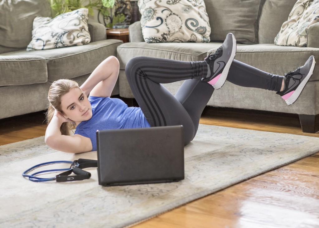 teen-girl-doing-home-workout-video-using-laptop-computer-doing-bicycle-crunches-sit-ups-abdominal_t20_gL6Ykx